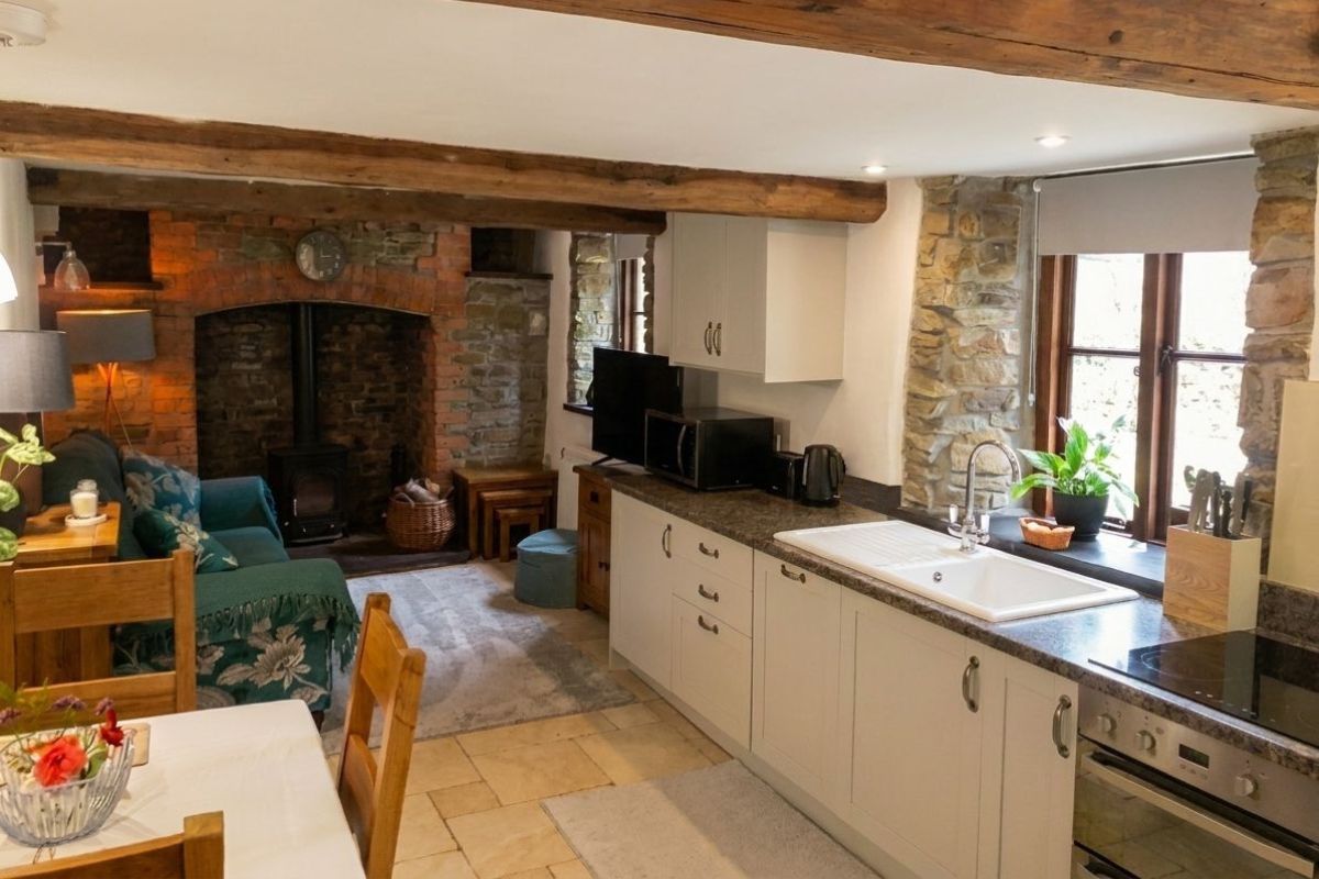 Cottage open-plan kitchen and living room with wood beams — after enhancement