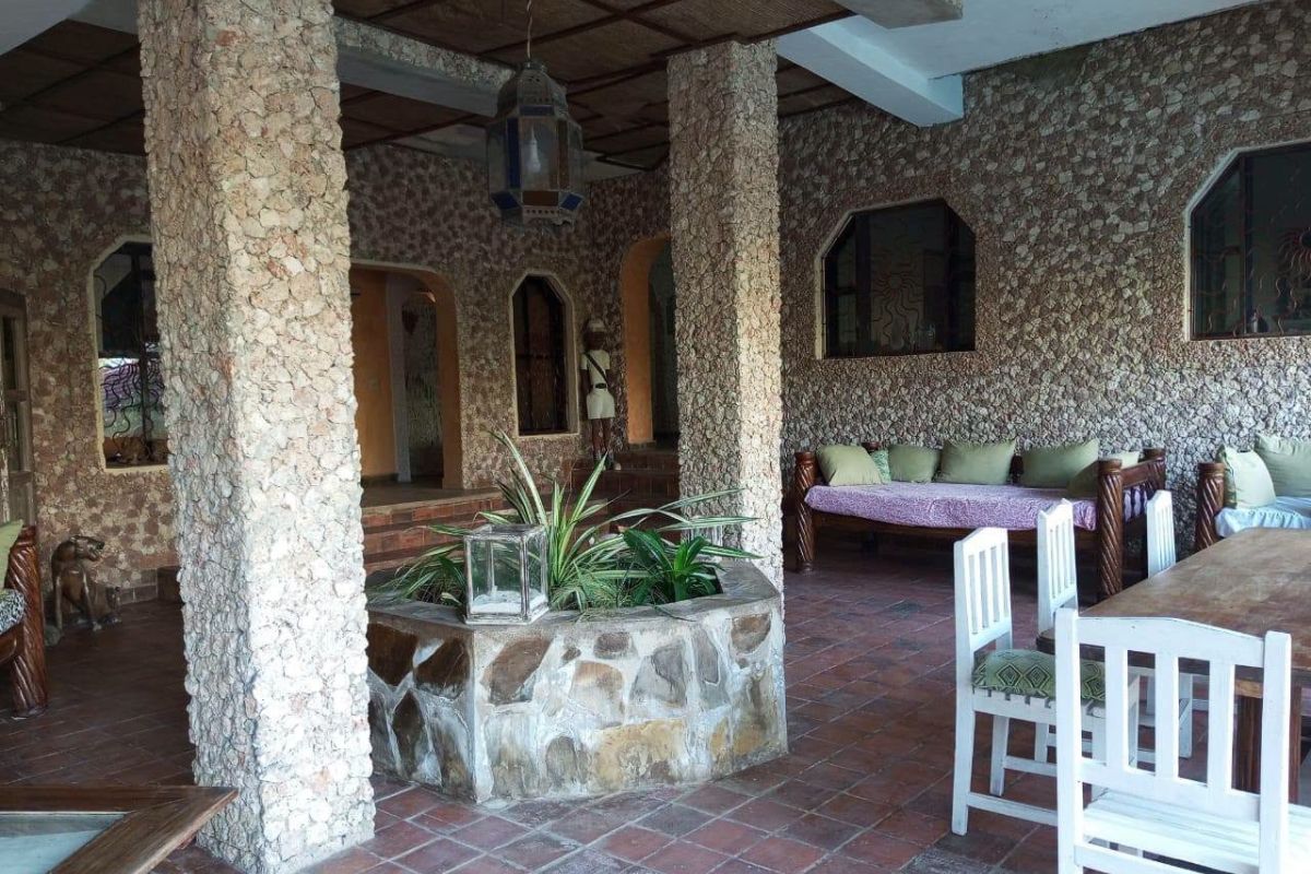 Covered stone terrace with seating at a holiday rental — original photo